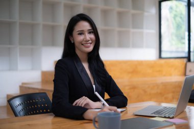 Genç lisans öğrencisi dizüstü bilgisayarla çevrimiçi ders çalışıyor.