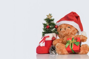A charming teddy bear wearing a Santa hat, surrounded by Christmas decorations, embodying the spirit of the holiday season.