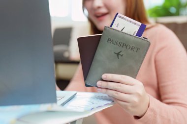 Bir gezgin, elinde bir pasaport ve biniş kartı tutarak yolculuğuna hazırlanır..