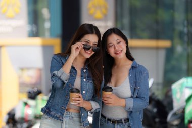 İki arkadaş dışarıda keyifli bir anı paylaşıyor. Kahvelerini yudumluyor ve akıllı bir telefonla iletişim kuruyor. Arkadaşlıklarının altını çiziyor..