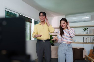 Bir çift, video görüşmesinde dans etmekten zevk alıyor. Sıcak bir ev ortamında bağlantılarını ve neşelerini sergiliyorlar..