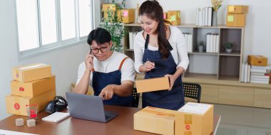 İki meslektaş, takım çalışması ve iletişimi vurgulayarak, modern bir ofiste paketleri yönetirken lojistik hakkında bir tartışmaya giriştiler..