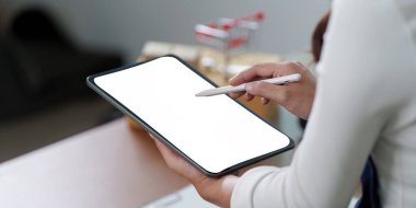 Bir kadın, dijital yaratıcılık ve yenilik potansiyelini temsil eden boş bir ekranla bir tablet tutuyor..