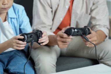 Kanepede video oyunu oynayan bir baba ve oğul arasında neşeli bir an. Aile bağlarını ve boş zamanlarını gözler önüne seriyorlar..