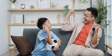 Mutlu bir baba ve oğul evlerinde keyifli bir anı paylaşırlar, bir futbol maçının zaferini heyecan ve kahkahalarla kutlarlar..