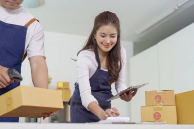 Küçük bir işletme ekibi, modern bir çalışma alanında ekip çalışması ve üretkenlik sergileyerek siparişleri verimli bir şekilde paketliyor..