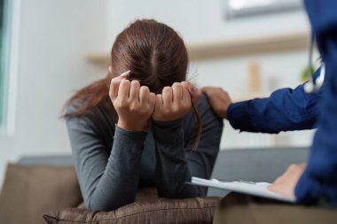 Bir terapist, ruh sağlığı seansı sırasında sıkıntılı bir kadını rahatlatır. Duygusal destek ve anlayışı vurgular..