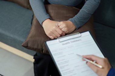 Bir sağlık hizmeti sağlayıcısı, bir hastayla sağlık özetini inceler, zihinsel sağlık desteği ve duygusal refahı vurgular.