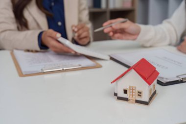 Müşteri emlak belgelerini incelerken, emlakçı da satın alma sürecinin detaylarını açıklar..