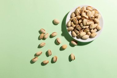 Açık yeşil arka planda küçük bir tabak şam fıstığı. Yüksek kalite fotoğraf