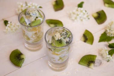 meyve, kivi, portakal ve armut hafif bir arka plan üzerinde küçük bardak