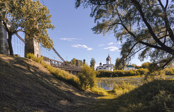 Suspension bridge across the river and the temple on the shore