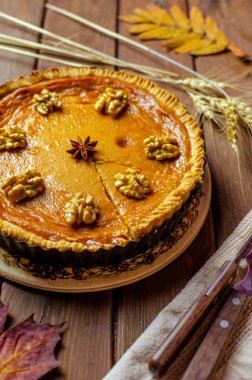 Şükran Günü ya da cadılar bayramı için yapılmış ahşap arka planda ev yapımı balkabağı turtası. Geleneksel Amerikan yemekleri.