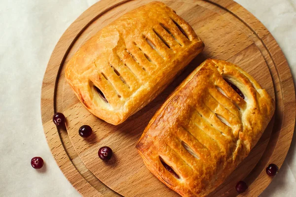 Tahta bir masada tatlı olarak böğürtlenli puf böreği. Yeni pişmiş..