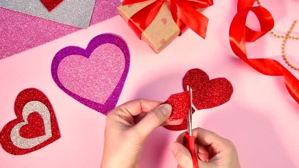 Regali di San Valentino o di compleanno. Regali di Giorno di San Valentino con un cuore di carta rosso su un tavolo di legno. Ragazza taglio cuore da carta rossa. — Video Stock