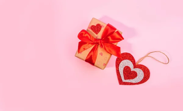 Dia dos Namorados ou presentes de aniversário. Os presentes de Dia de Valentim com um coração de papel vermelho em um contexto rosa. Vista superior. — Fotografia de Stock
