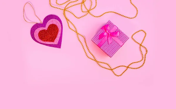 Valentin nap vagy szülinapi ajándék. Valentin napi ajándékok piros papírszívvel, rózsaszín háttérrel. Felülnézet. — Stock Fotó