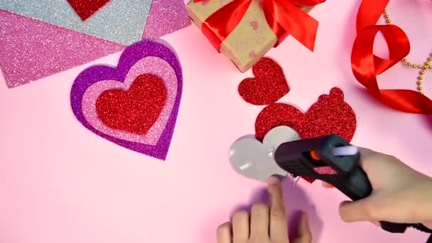 День Святого Валентина або День народження. День святого Валентина подарунки з червоним паперовим серцем на дерев'яному столі. Дівчина червона від паперу. Рожевий фон. Материнська картка. — стокове відео