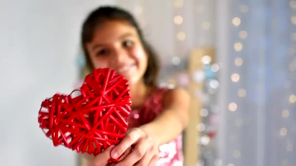 Røde hjerte tæt op i hænderne på lille mørkt hår smilende pige på Valentinsdag. Langsom bevægelse. – Stock-video