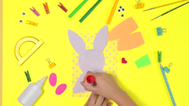 DIY y creatividad de los niños. Instrucciones paso a paso: Crea una tarjeta de Pascua con conejito y zanahoria. Artesanía de Pascua hecha a mano para niños. — Vídeo de stock