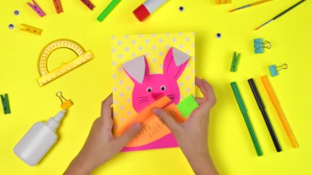 DIYと子供の創造性。ステップバイステップの指示:ウサギとニンジンでイースターカードを作成します。手作りイースタークラフトの子供たち. — ストック動画
