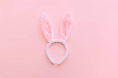 Paskalya günü pembe arka planda tavşan kulakları ve yumurtalar. Baharda Paskalyayı kutluyoruz. Üst görünüm.