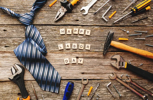 Happy labor or father day greeting card or background. Construction tools on rustic wooden background.