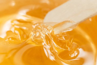 Beyaz arka planda şeffaf bir kavanozda bal ya da ballı şeker ezmesi. Şekerleme. Deplasyon ve güzellik konsepti. Ağda yapıyorum. Yakın plan..