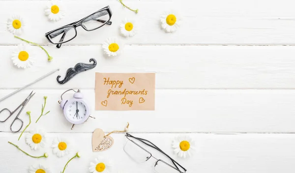 Happy Grandparents day background. Flowers on white background and greetings. Flatlay.
