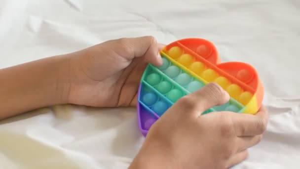 Bunte Antistress-Sensor-Spielzeug Fidget Push Pop es in Kinderhänden. — Stockvideo