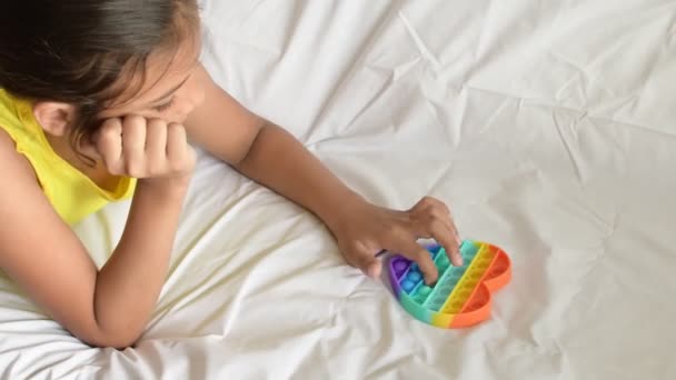 Colorido antistress brinquedo sensorial fidget empurrá-lo pop-lo em mãos de crianças. — Vídeo de Stock