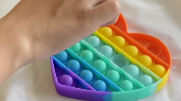 Juguete sensorial antiestrés colorido fidget push pop it en las manos de los niños. — Vídeo de stock