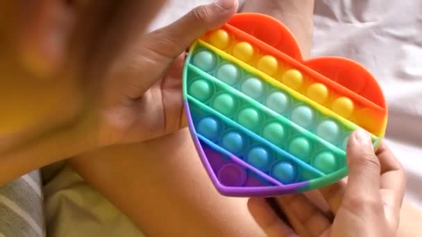 Kolorowe antystresowe zmysłowe zabawki fidget push pop to w rękach dzieci. — Wideo stockowe