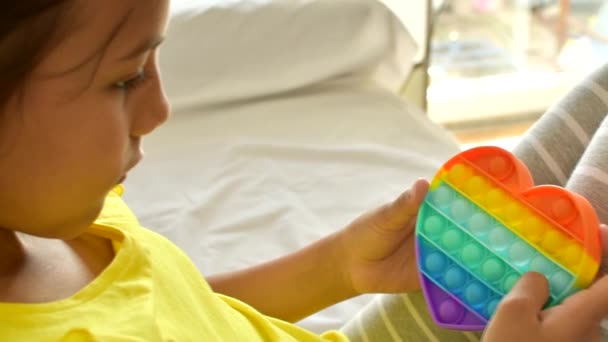 Barevné antistress smyslové hračky vrtění tlačit pop to v dětských rukou. — Stock video