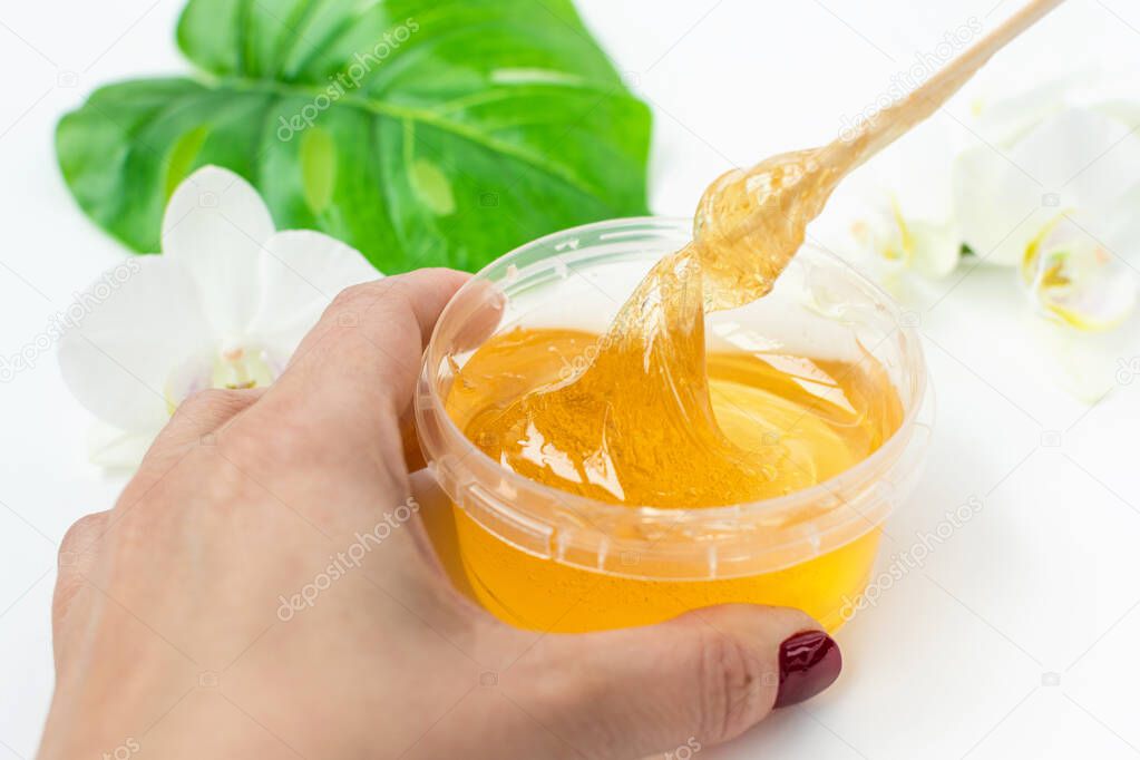 A master stir the sugar paste before removing unwanted hair. Sugaring. Depilation. Epilation. Beauty concept.