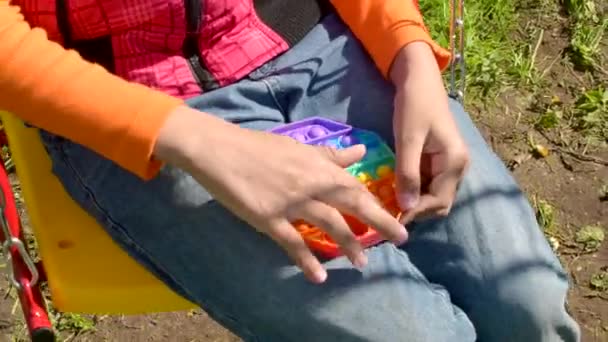 Kolorowe antystresowe zmysłowe fidget zabawki push pop go w rękach dzieci. Pokaż zabawkę. — Wideo stockowe