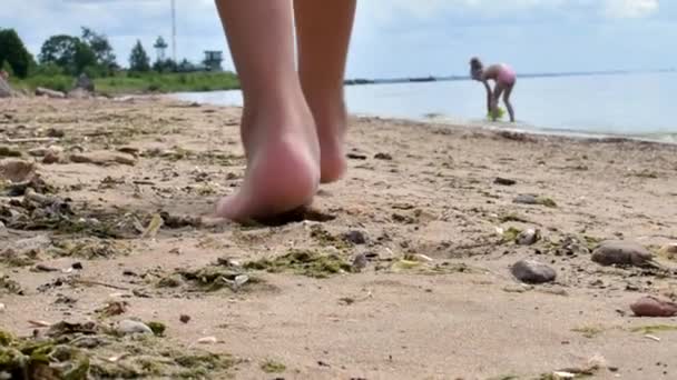 Fötter små flickor springer barfota på den gyllene sandstranden. Långsamma rörelser. — Stockvideo
