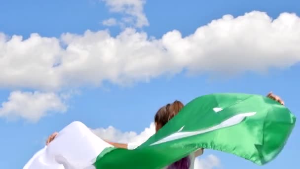 Meisje zwaaiend vlag van Pakistan buiten over blauwe bewolkte lucht en gouden tarwe. Gelukkige onafhankelijkheidsdag — Stockvideo