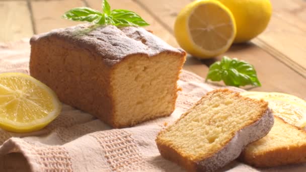 Citronová libra dort na rustikální dřevěné pozadí s citrónem. — Stock video