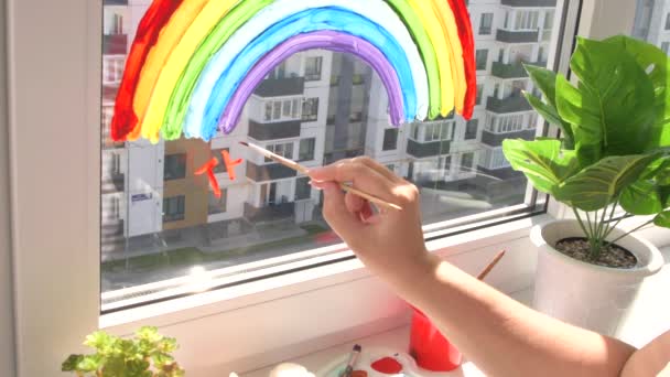 Dívka malování duha na okně během karantény doma. — Stock video
