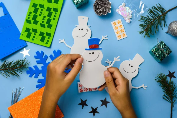 Noel ağacı süslemeleri. Mavi ahşap arka planda kardan adam parçaları. Noel, fikir üretir. Üst görünüm.