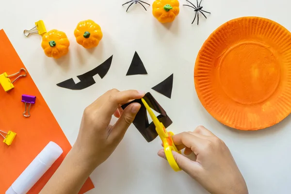 Cuts of paper for Halloween. Hand cut paper. Pumpkins. Scissors and glue. On a light background. Top view. Flat lay.