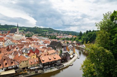Esk Krumlov 'un tarihi kahverengi köşeli evleri, Vltava Nehri' nin kıvrımları ve yemyeşil tepelerle çevrili ortaçağ mimarisi. Bir Çek peri masalı..