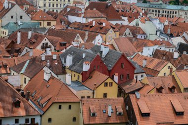 Cesky Krumlov 'un kalbine yakından bak. Sıkışık, turuncu ve kahverengi kiremit çatılı ve pastel cepheli tarihi evler. Ortaçağ dokusu.