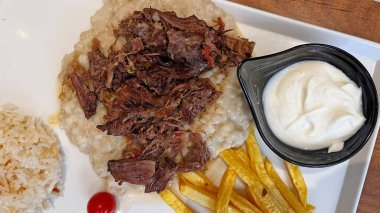 Geleneksel bir Türk yemeği kebap (doğranmış et), pirinç, patates kızartması ve yoğurt ile servis edilir..