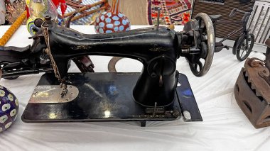 Masanın üzerinde duran eski bir dökme demir dikiş makinesi. Nostaljik bir el işi ekipmanı..