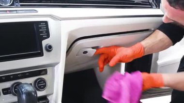 Profesyonel bir oto yıkama uzmanı mikro fiber bez kullanarak aracın gösterge panelini ve iç panellerini titizlikle temizler..