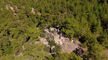 Doyran Manastırı 'nın etkileyici kalıntılarını, Antalya' nın ormandaki saklı hazinesini ve büyüleyici doğal çevresini gösteren panoramik bir dron görüntüsü..