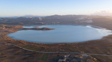 Yarisli Gölü 'nün gün batımı manzarası, yarımada şeklindeki kıyı şeridi ve çevresindeki tarım arazisi..