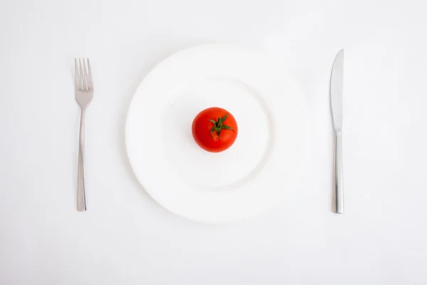 Piastra bianca con pomodoro isolato su sfondo bianco — Foto Stock